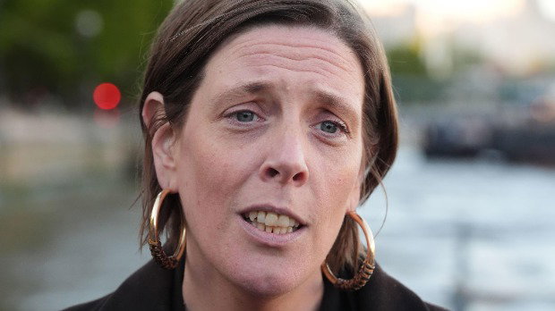 Jess Phillips has short brown hair tucked behind her ears. She is wearing a dark jacket and faces the camera.