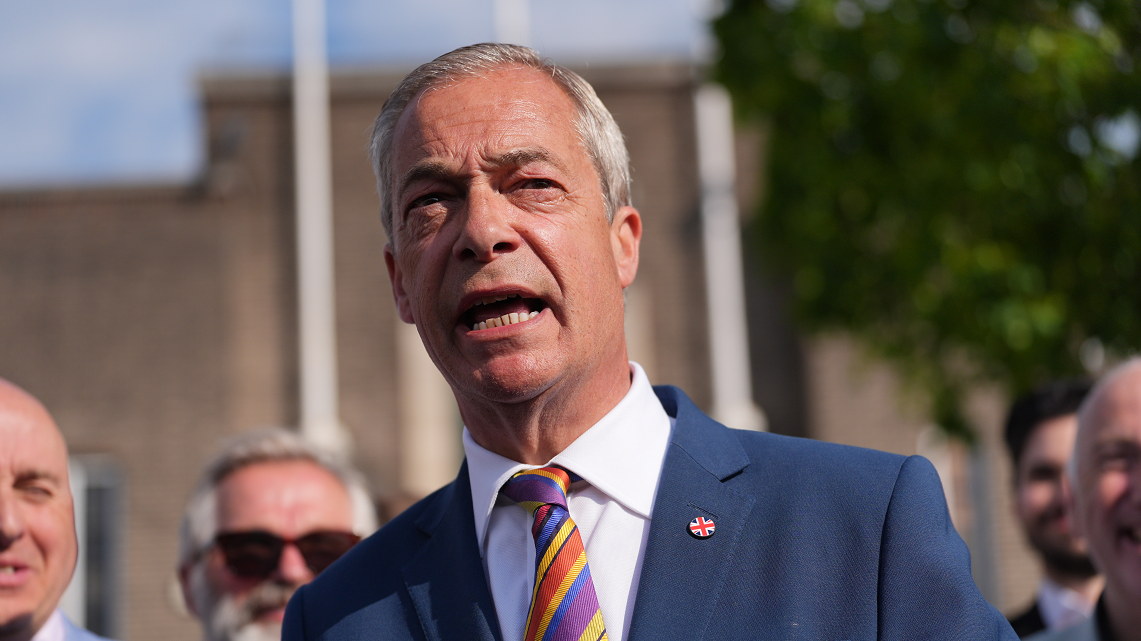 Reform UK leader Nigel Farage during a visit to Havering Town Hall in Romford, following the 2026 local election results. He wears a navy suit, striped tie and white shirt.