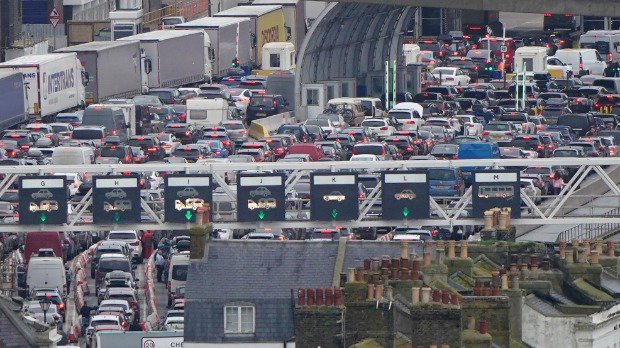 Cars are jammed end to end in a queue at the border while waiting to board ferries at the Port of Dover while lorries queue to the left in a different lane.