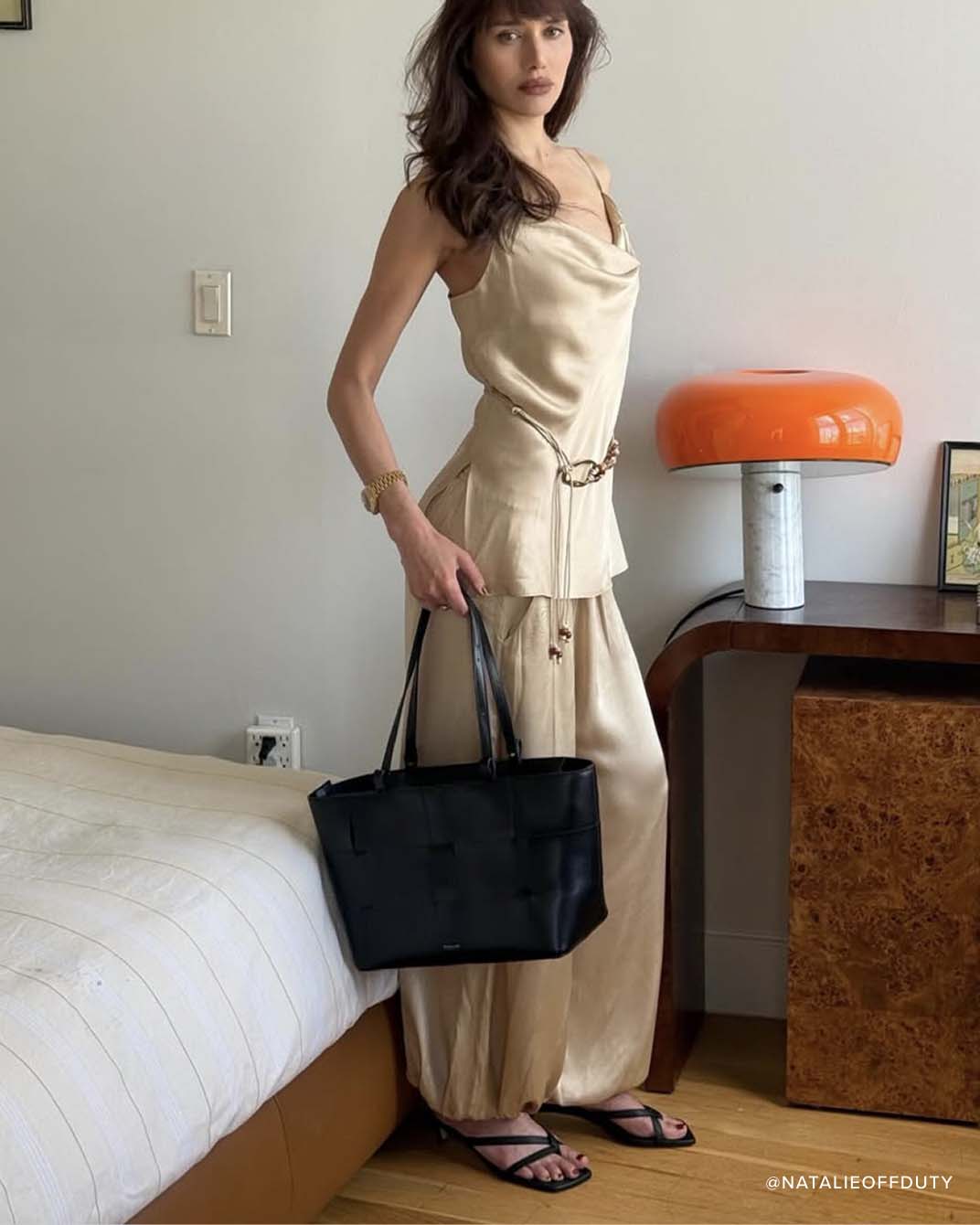 ELAINE heeled sandal in black nappa styled with neutral silk balloon pants and matching tank top, model standing in beautiful room
