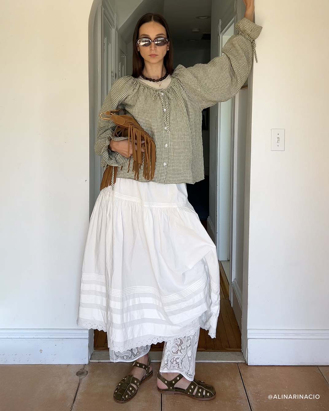 SERA fisherman sandal in olive with gold studs styled with lace pants under a white skirt, paired with gingham longsleeve and brown fringe bag