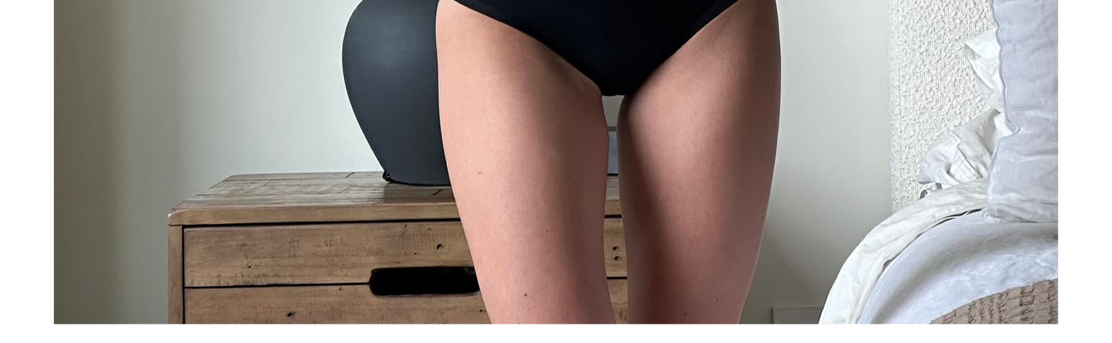 A women standing infront of an mirror wearing subset black bikini
