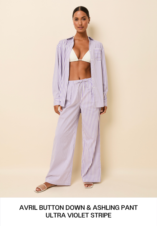 Woman wearing purple striped shirt and pant and white bikini top.