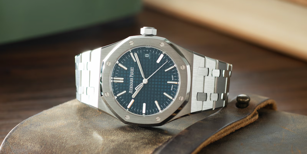 Pre-Owned Audemars Piguet Royal Oak on its side on leather bound book on desk