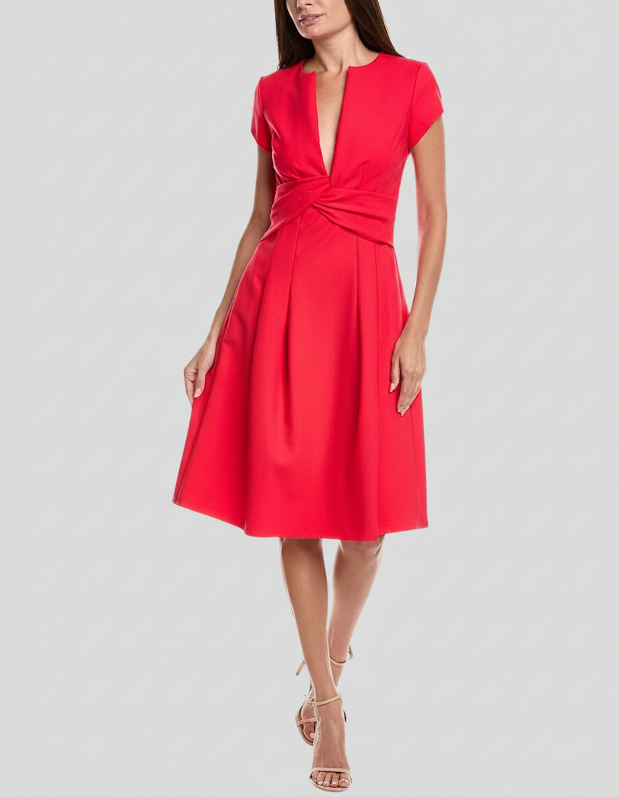 Woman in a red V-neck dress with a twisted waist and pleated skirt, wearing nude strappy heels.