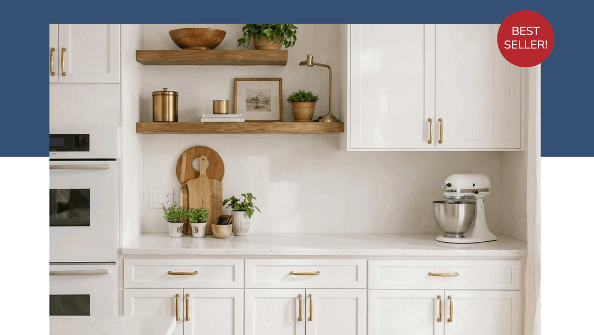 Best Seller: Weston White Shaker. Kitchen with white cabinets with gold pulls, and some wooden floating shelves.