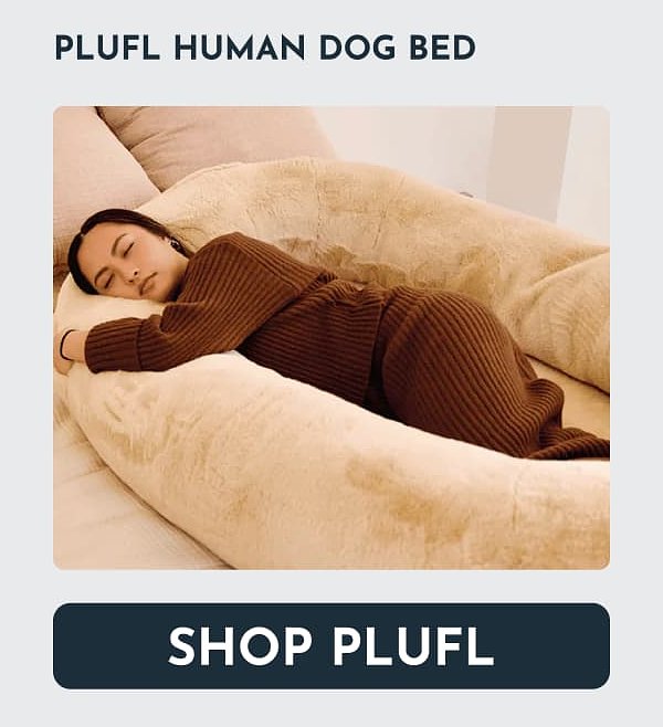 A person sleeping comfortably on a fluffy dog bed.