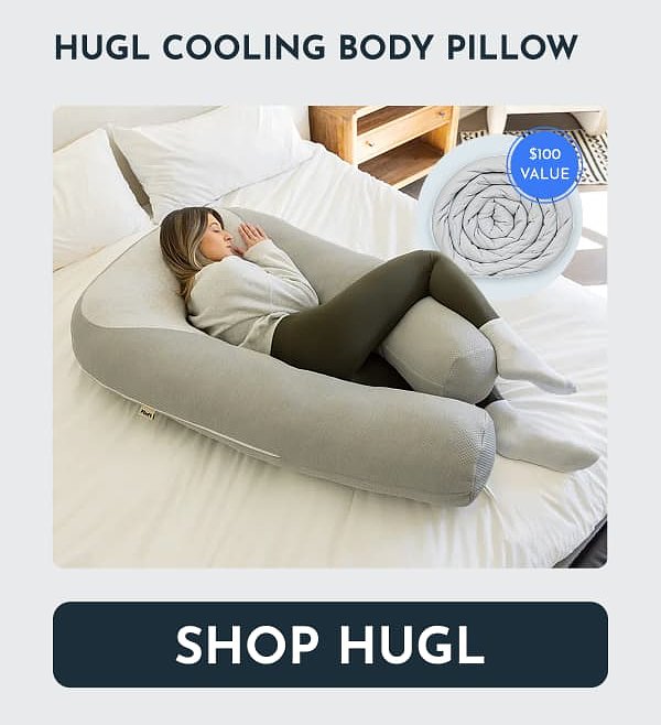 A woman resting with a large, gray cooling body pillow on a bed.