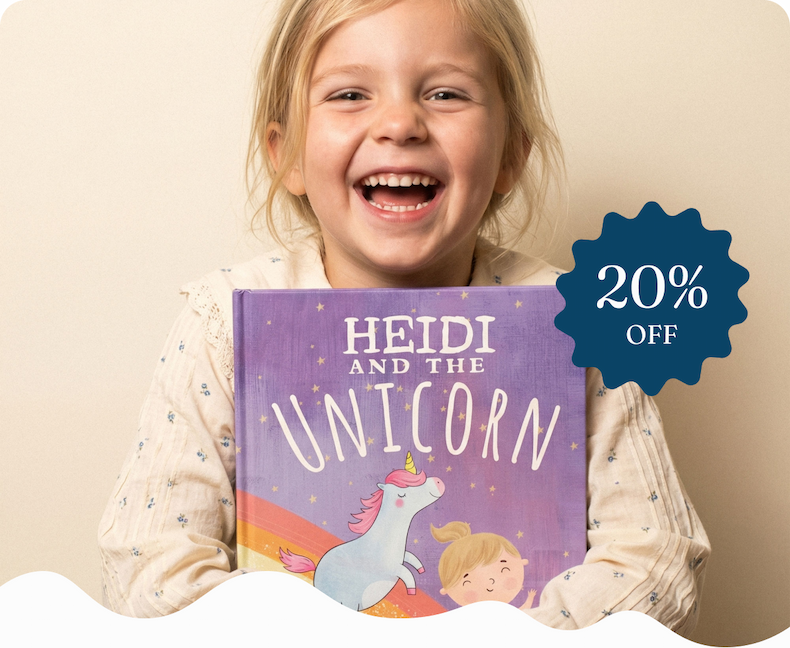 A young girl laughing and holding a personalised "Heidi and the Unicorn" book with an illustrated unicorn on the cover