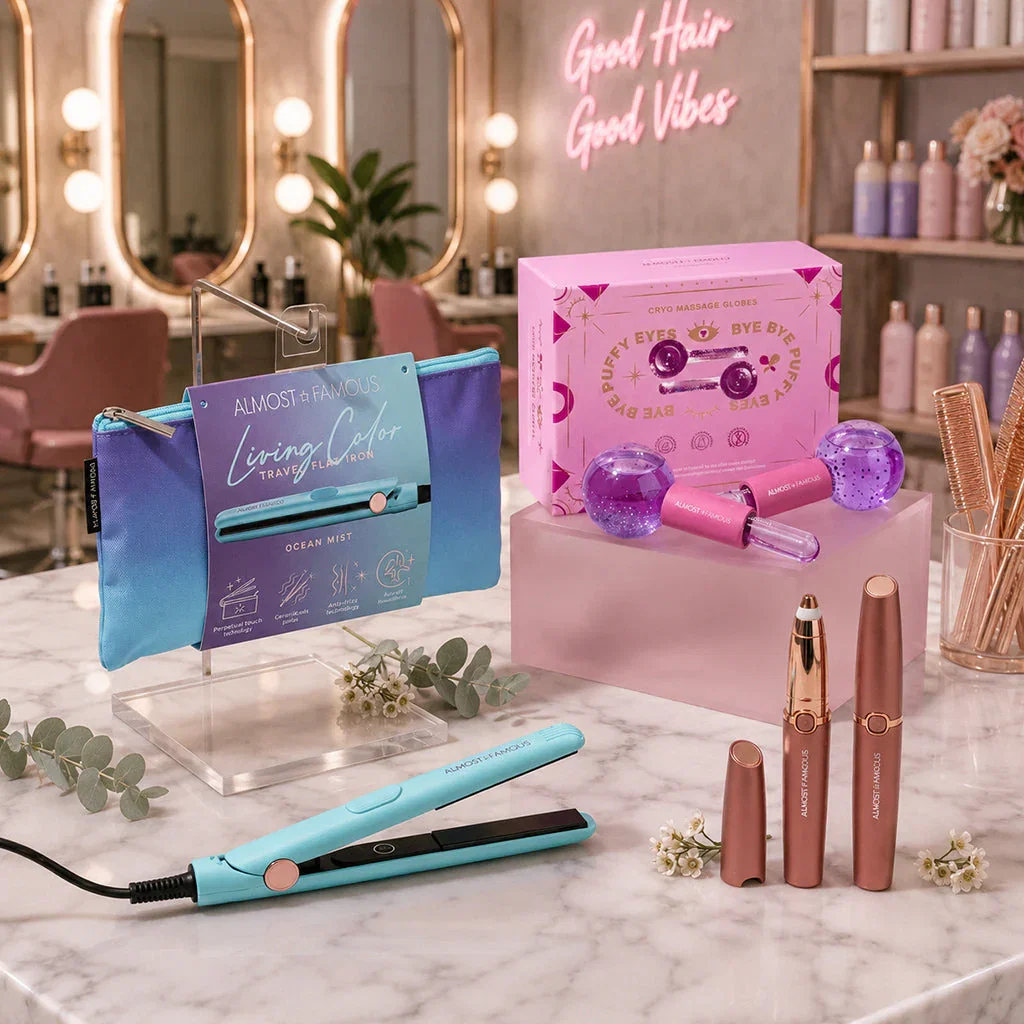 A beauty salon display featuring hair styling tools and cosmetics including a turquoise hair straightener, pink eye roller set, and rose gold lipsticks on marble counter.