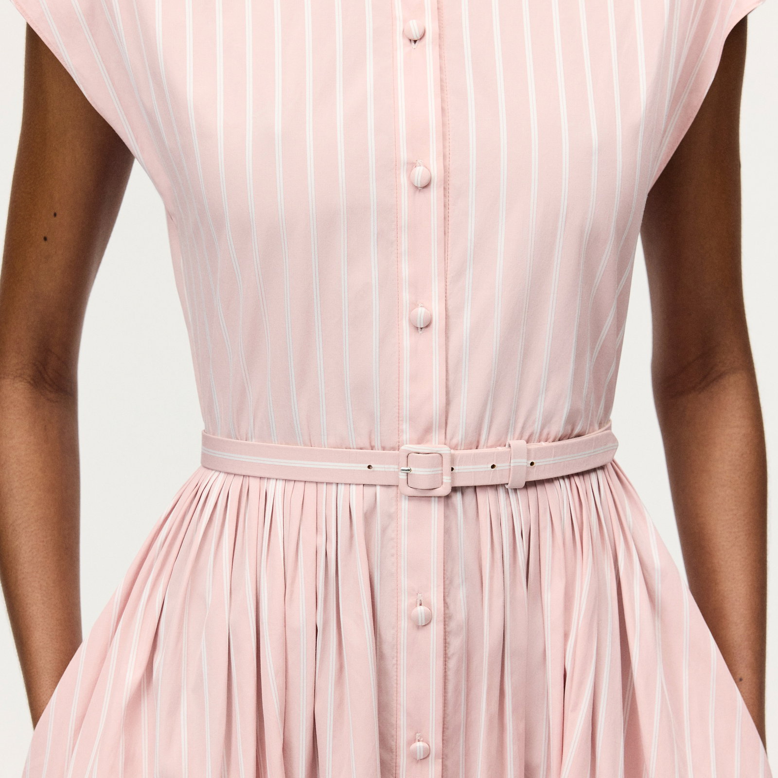 Image of a model wearing the genevieve dress in pale pink and white stripes.
