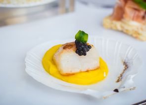 Crema de calabaza, helado de mango y pescado en hoja de plátano