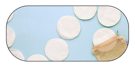 Image of reusable cotton makeup remover pads arranged on a soft blue background beside a mesh wash bag.