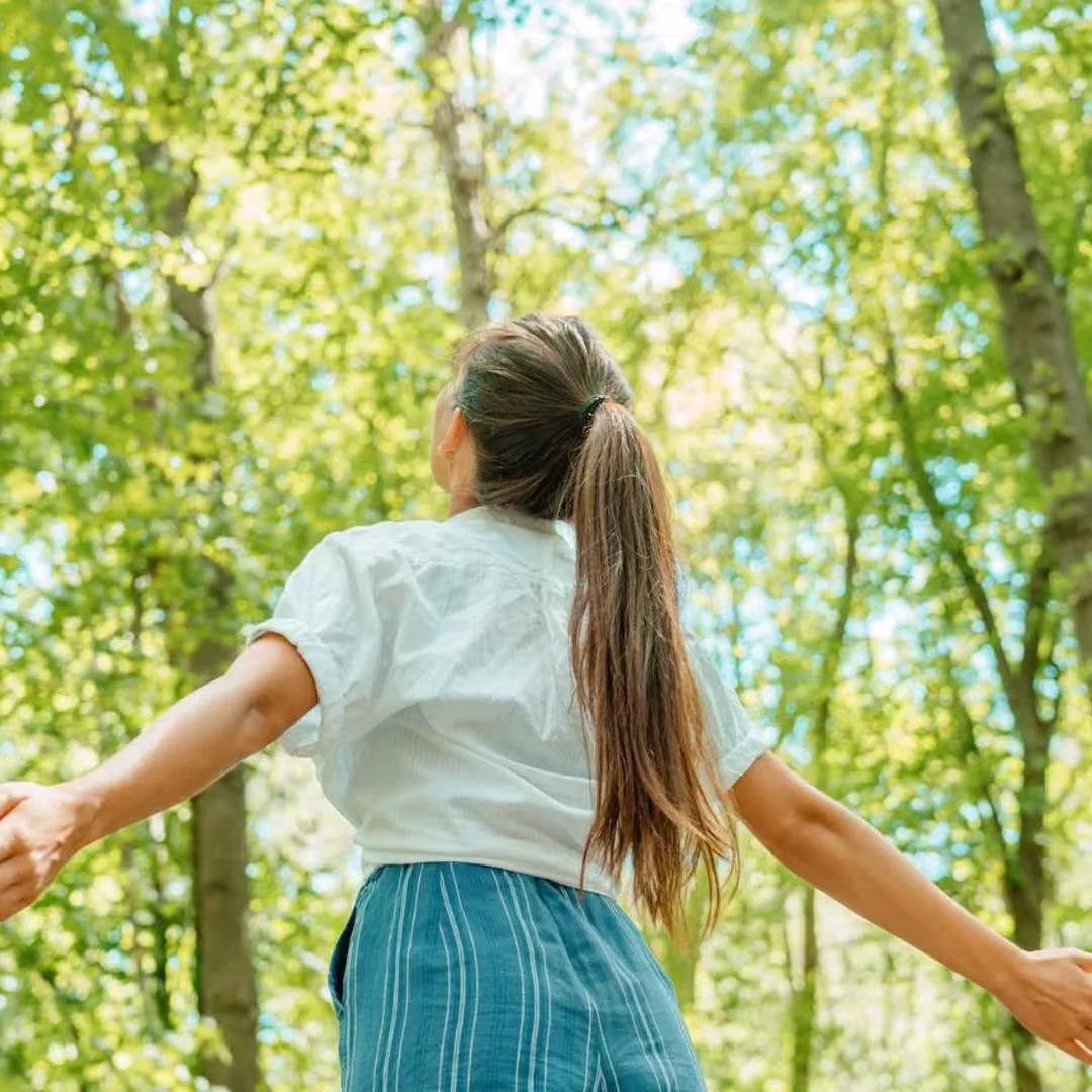 Woman standing amongst trees