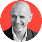 Black and white headshot of Evan Davis, a man with close-cropped hair and beard, on a red background.
