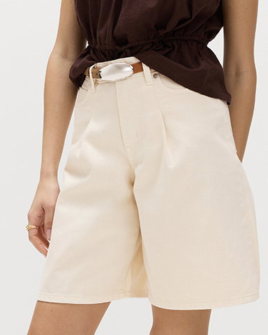 Close up of woman wearing Denim Pleat Front Wide Shorts in Ecru