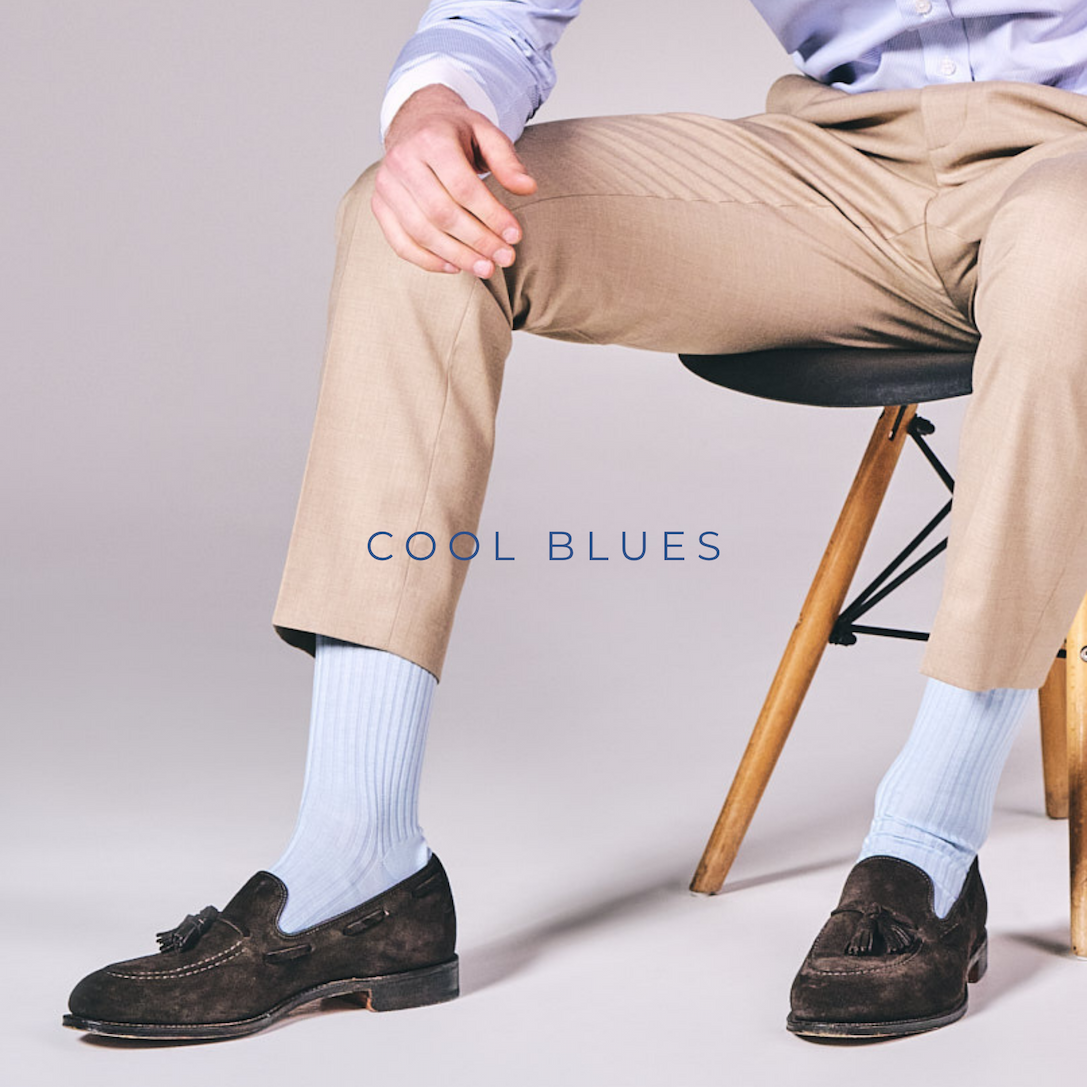 man sitting on chair wearing blue socks and loafers