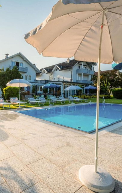 Hotel Außenansicht mit Pool, Liegen und Sonnenschirmen