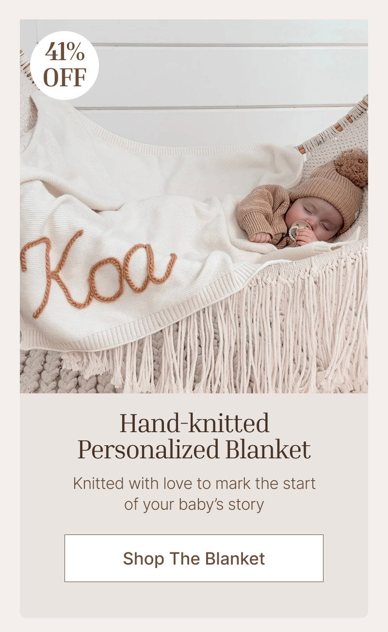 Baby sleeping beneath a personalized knit blanket in a light crib setting with soft neutral bedding and textures.