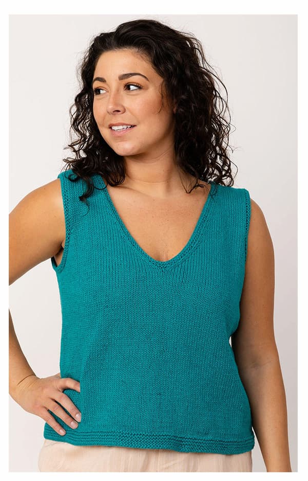 A model is wearing a knit tank in bright teal yarn. >>