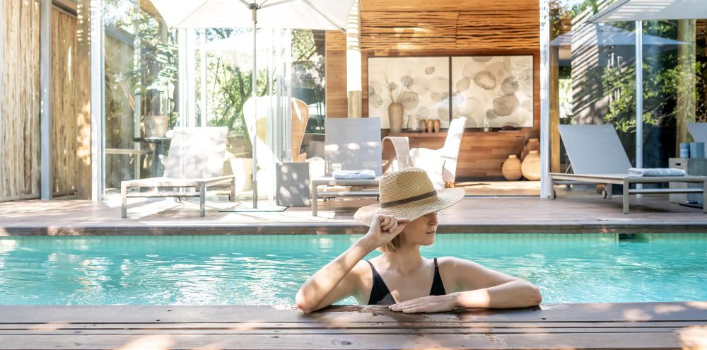 Solo traveller relaxing beside a private pool at Singita Lebombo