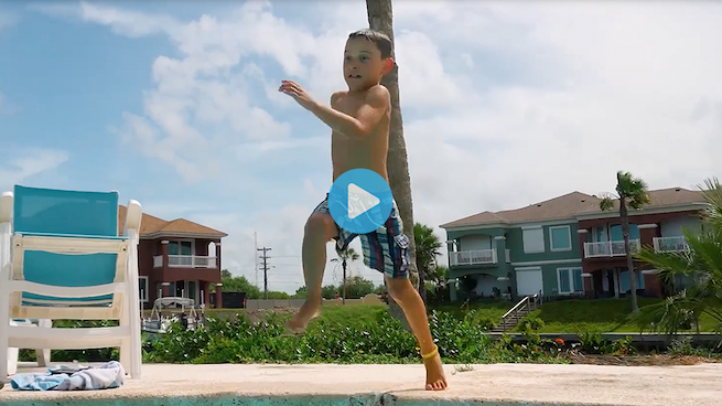 Boy jumping into a pool 