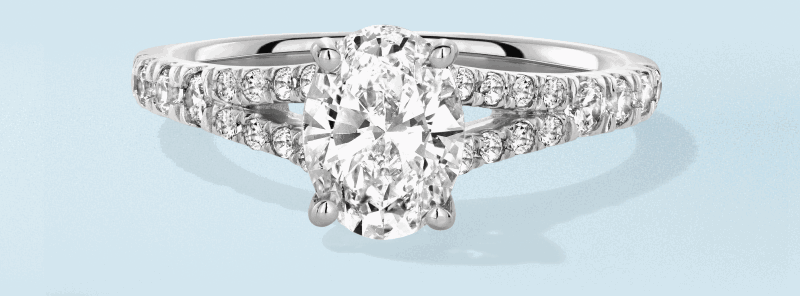 White metal oval diamond engagement ring with double pavé band.