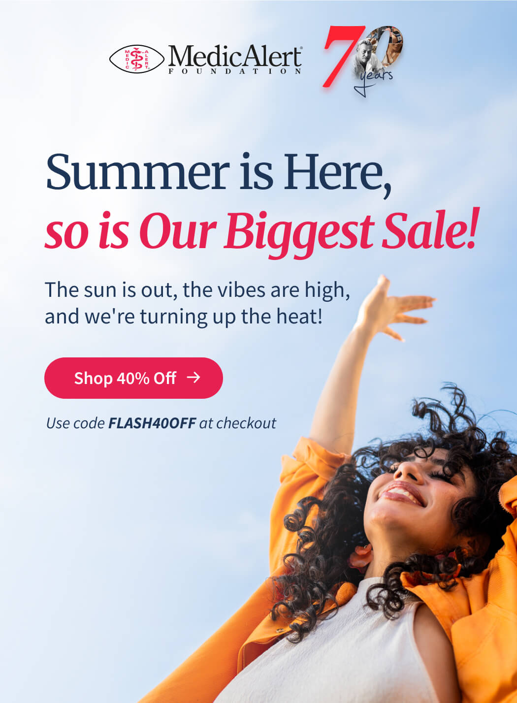 Header image for the MedicAlert Foundation Biggest Sale, celebrating '70 Years'. The main text reads 'Summer is Here, so is Our Biggest Sale!'. Below, it states 'The sun is out, the vibes are high, and we're turning up the heat!'. A prominent red button is labeled 'Shop 40% Off'. At the bottom, the call to action reads 'Use code FLASH40OFF at checkout'. The image shows a young woman with curly brown hair, wearing a white halter neck top and an orange jacket, leaning back with her arms raised joyfully against a sunny sky.