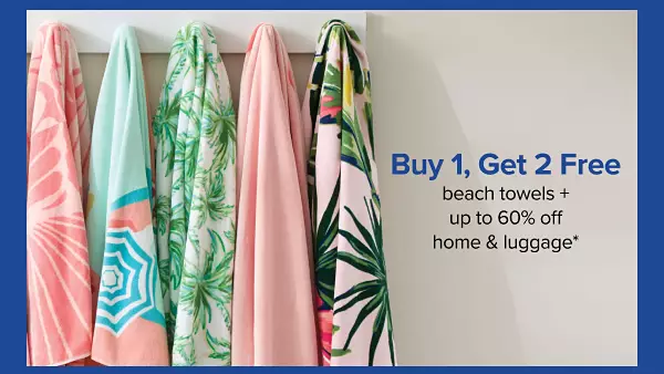 Buy one get two free beach towels. Plus up to 60% off home and luggage. A rack of hanging beach towels.