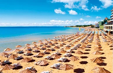 Photograph of beach in Bulgaria with sun lougers and sun umbrellas.