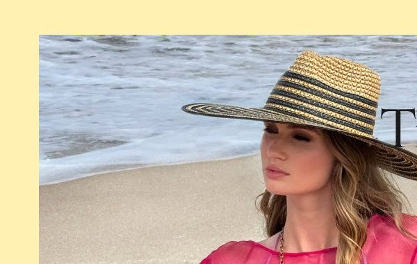 A woman in a colorful dress and straw hat poses against flowers and a beach backdrop.