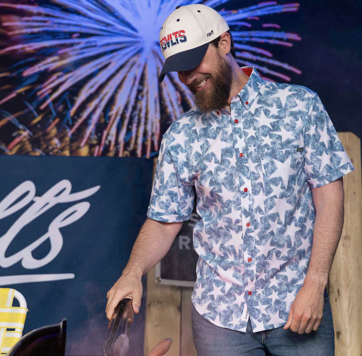 Man grilling in front of fireworks