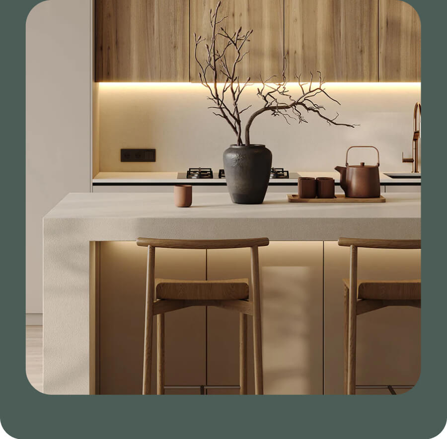 A warm, minimalist kitchen featuring light wood cabinetry, a sleek island with bar stools, and soft under-cabinet lighting. A simple vase with bare branches adds a calm, modern touch.