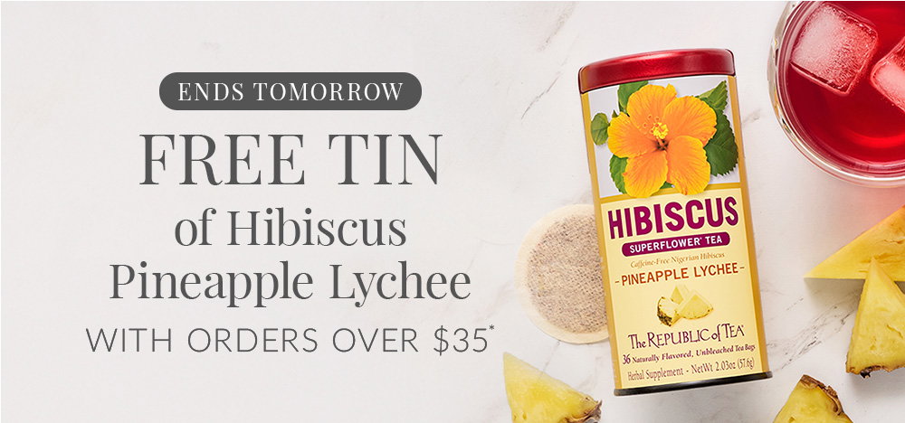 Tin of Hibiscus Pineapple Lychee tea with a teacup of next to tin with ice and pineapple pieces surrounding tin