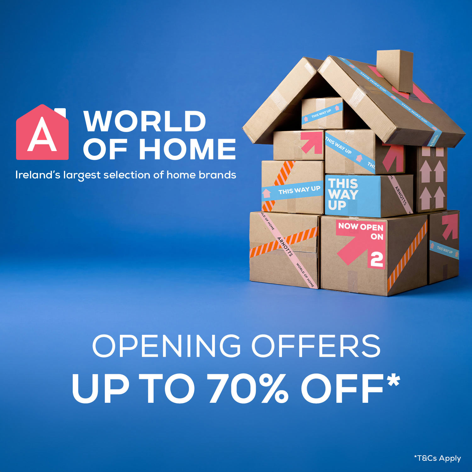 Cardboard boxes arranged to form a house, with labels like 'This Way Up' and 'Now Open'. Text reads 'A World of Home: Ireland's largest selection of home brands. Opening offers up to 70% off.' Background is blue.
