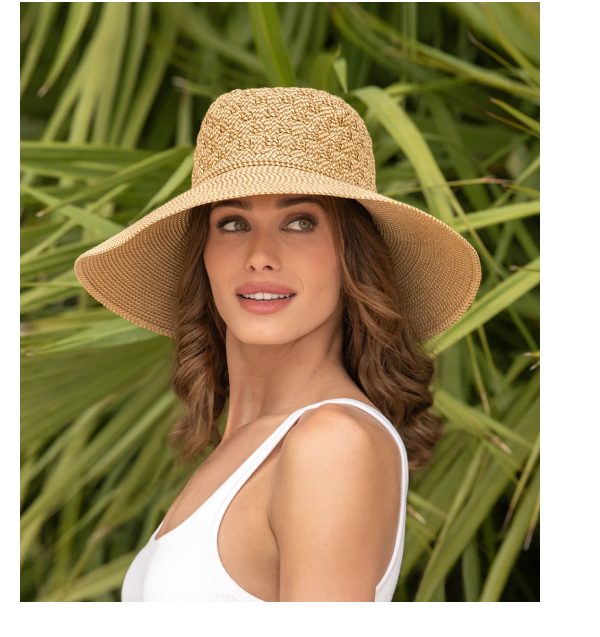Woman wearing a wide-brimmed straw hat with a tropical background.