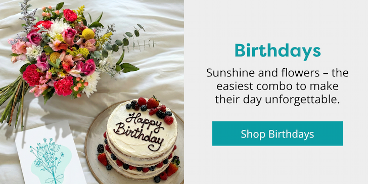 Callia bouquet and birthday cake on a bed