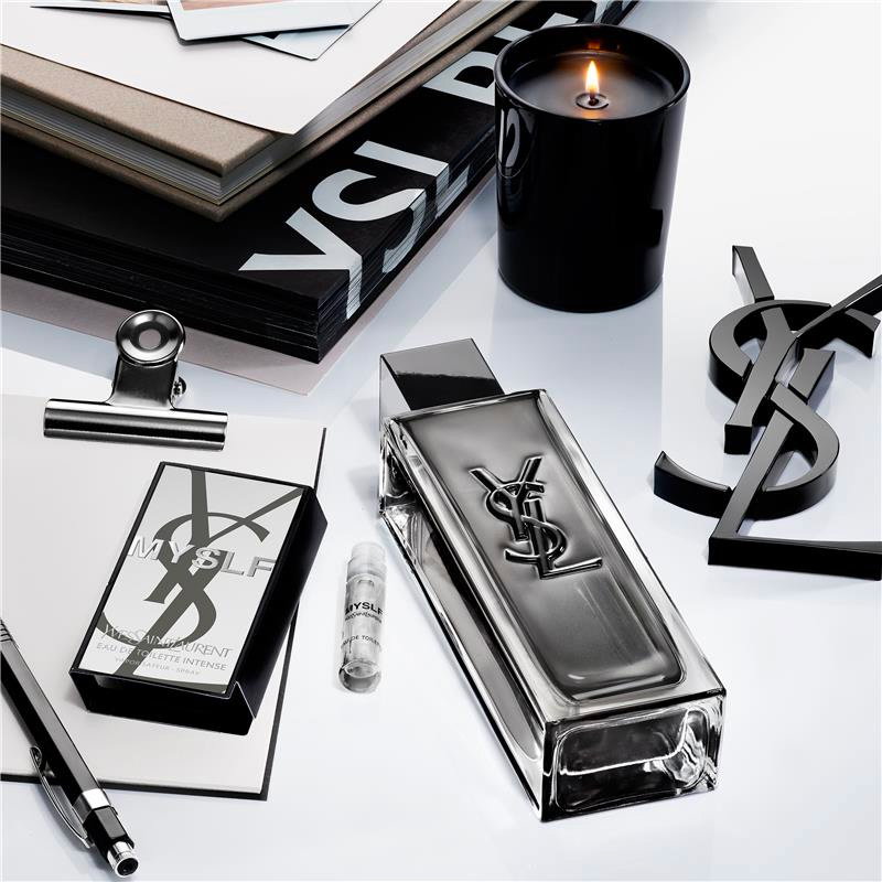 YSL MYSLF fragrance bottle, candle, and accessories on a white surface.