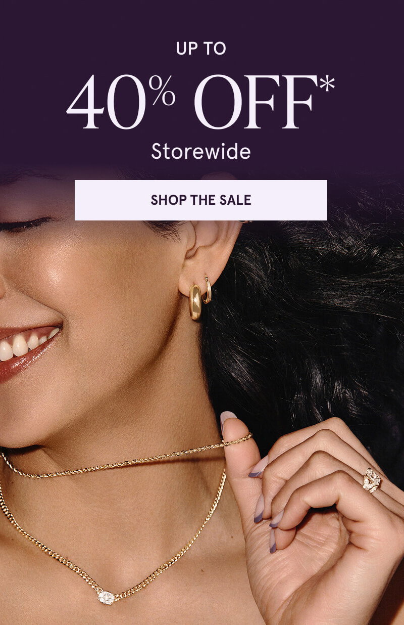 Model layered in gold-set jewelry, including a chain with diamond pendant & gold hoops & huggies. Up to 40% OFF Storewide. Click here to shop the sale