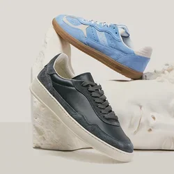 Deux baskets, une noire et une bleue, présentées sur et au-dessus d'une tête de sculpture classique blanche sur un fond neutre.