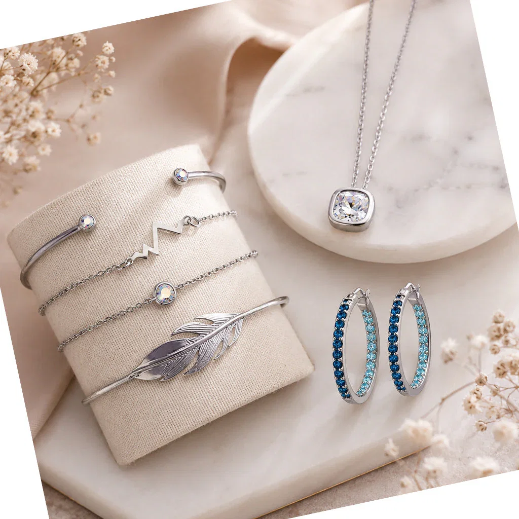 New Micalla Callura jewelry collection featuring silver bracelets, necklace, and gemstone hoop earrings on cream displays.