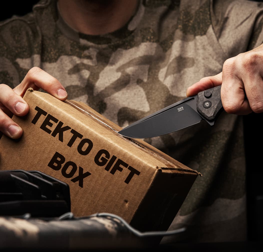 Man cutting Tekto gift box with folding knife F3 Charlie.