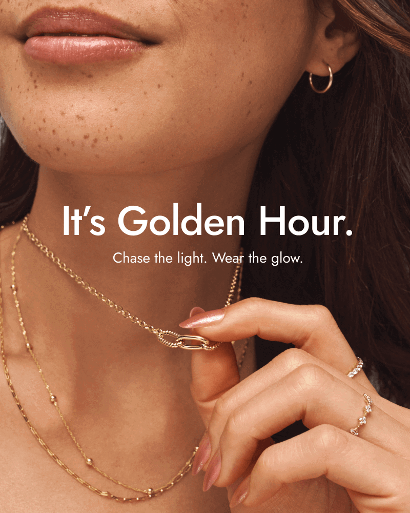 Woman wearing gold necklaces, gold and diamond rings, and small gold hoops. It’s golden hour. Chase the light. Wear the glow.