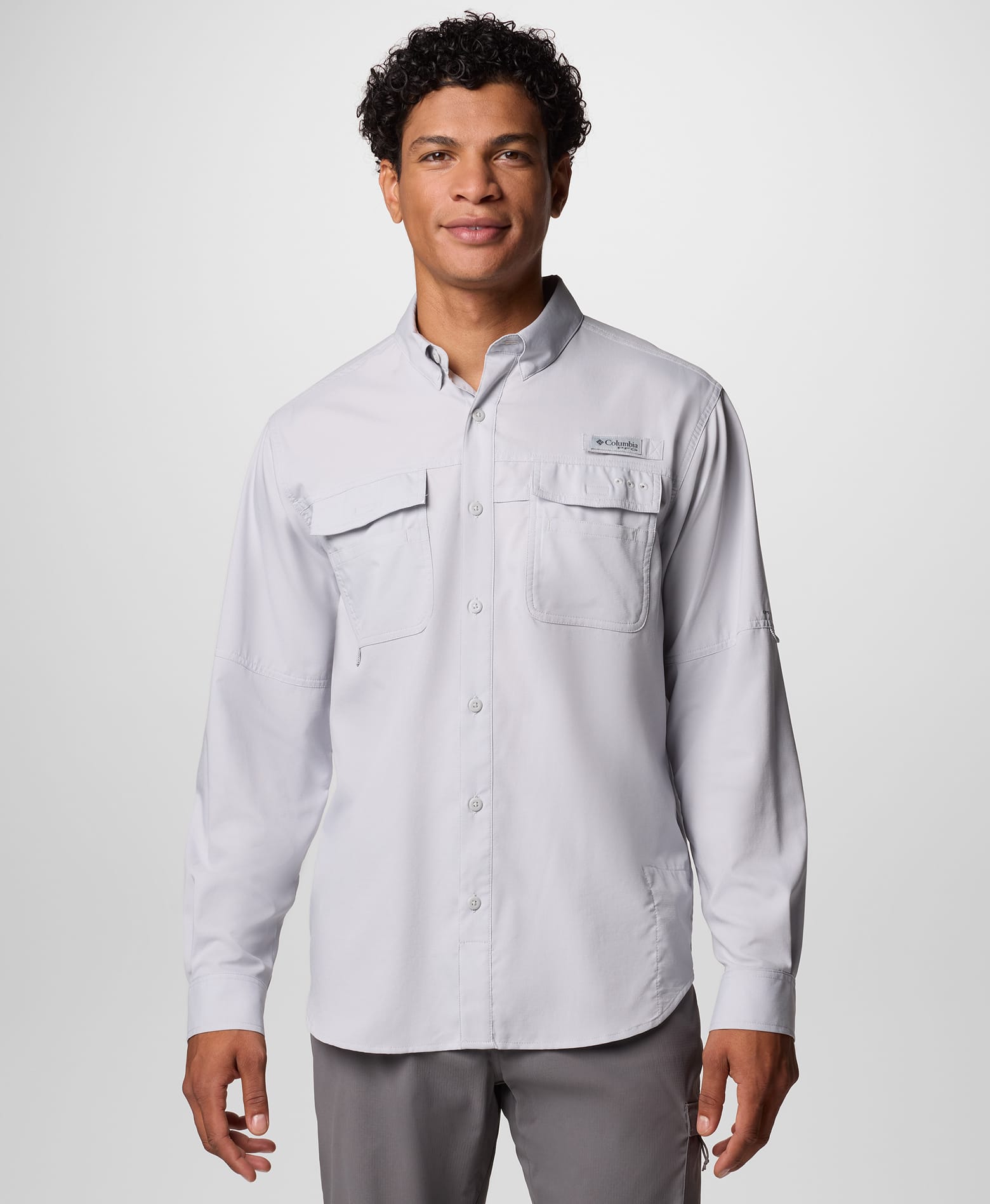 A man wearing a light gray long sleeve button up shirt.