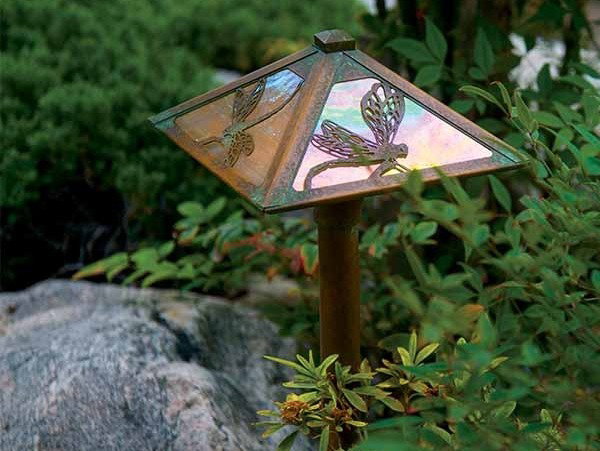 A garden lantern with dragonfly filigree.