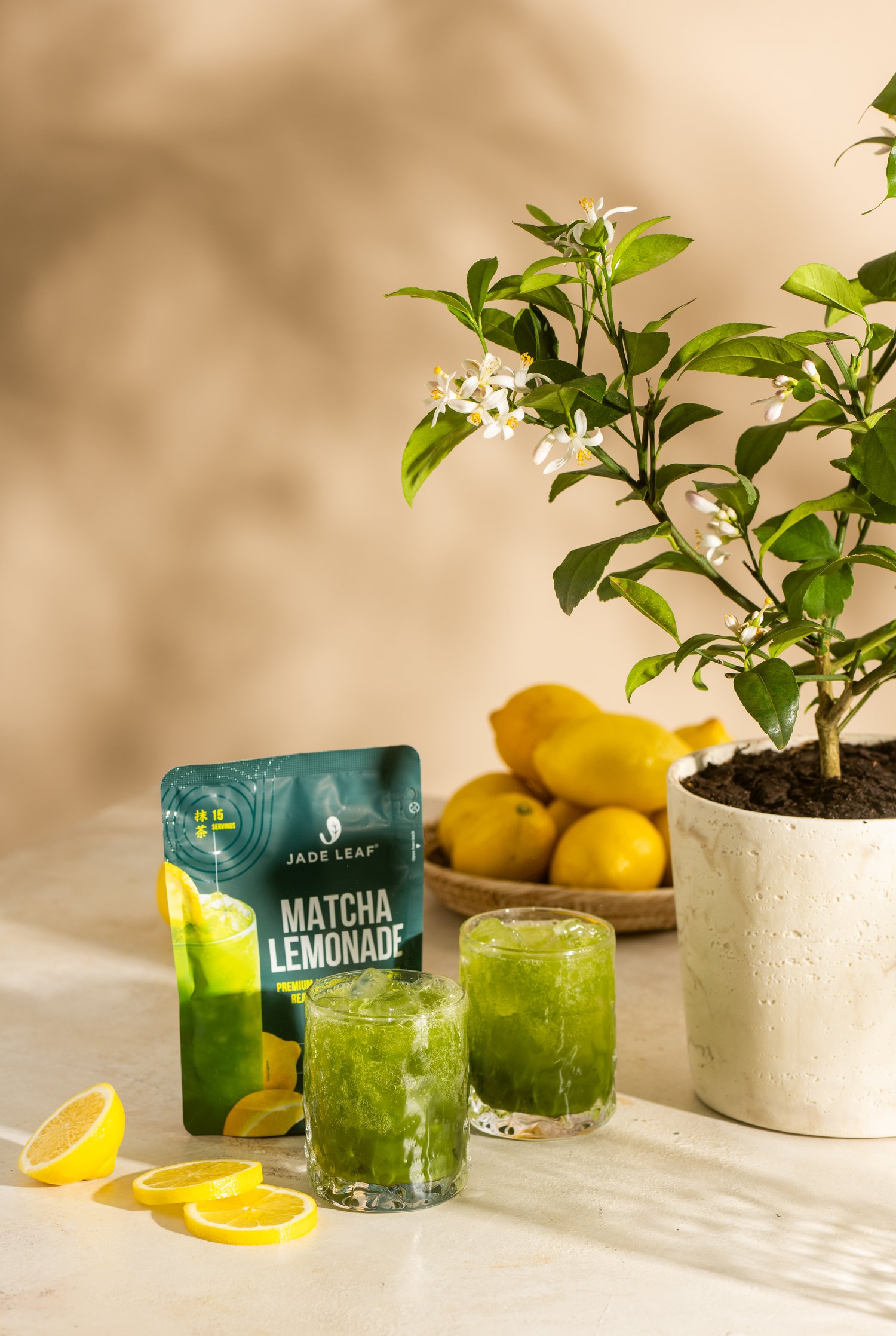 Matcha Lemonade Mix with iced glasses and a lemon tree