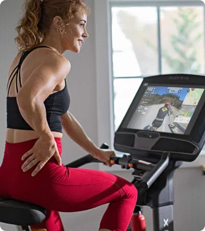 Woman in red leggings running on Matrix treadmill in home gym