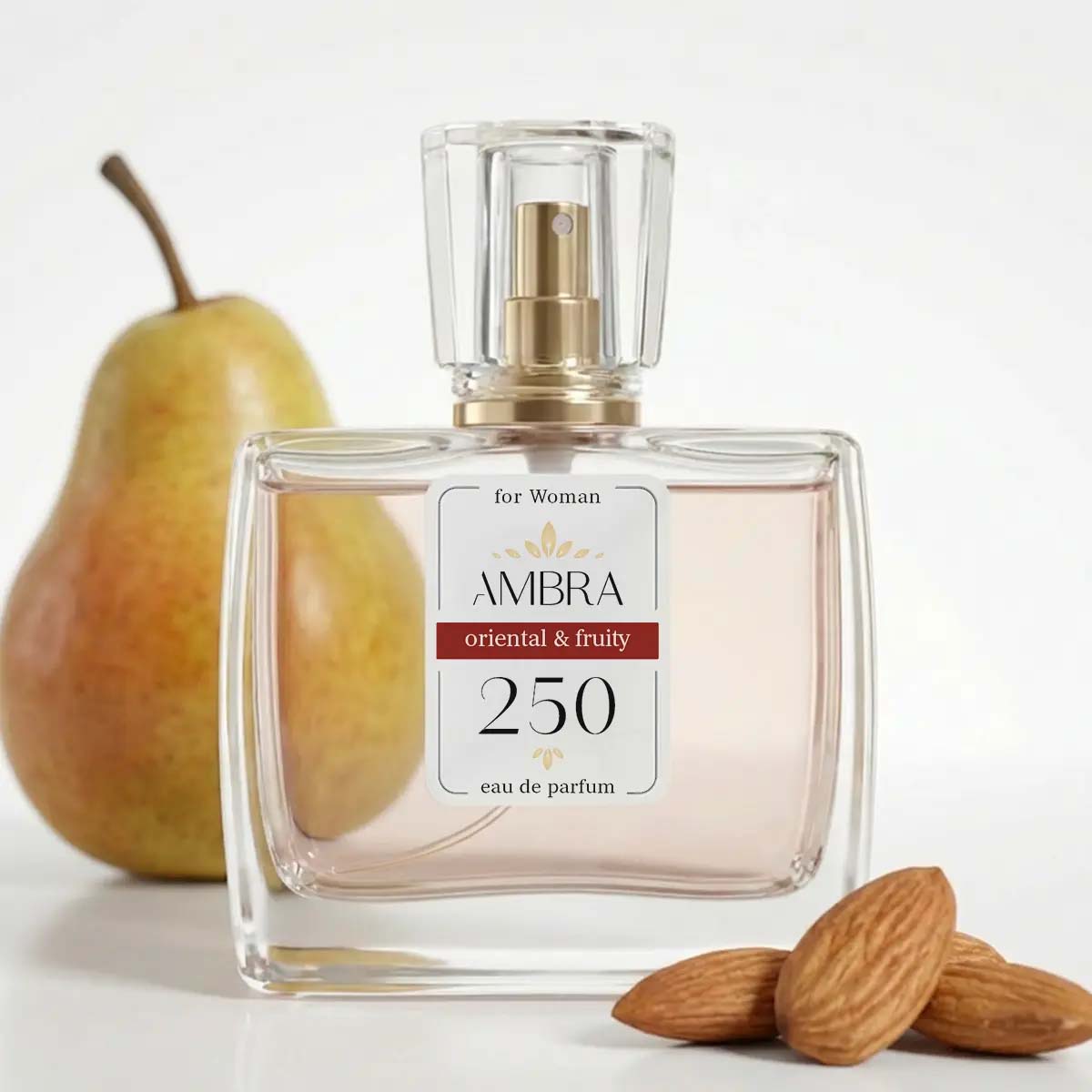 Glass bottle of Ambra 250 oriental & fruity eau de parfum for women, with pear and almonds in the background