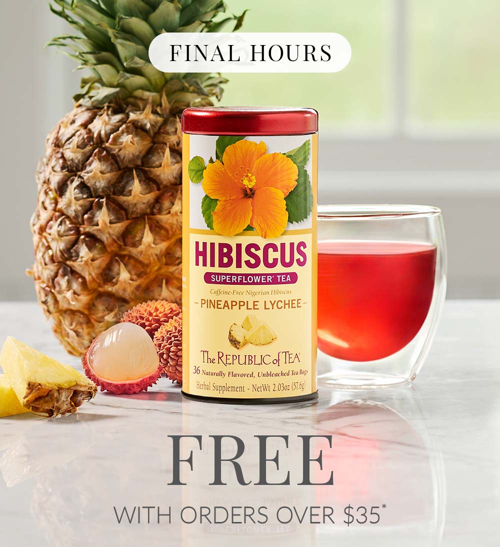 Tin of Hibiscus Pineapple Lychee with pineapple and teacup behind tin with pieces of pineapple in the foreground