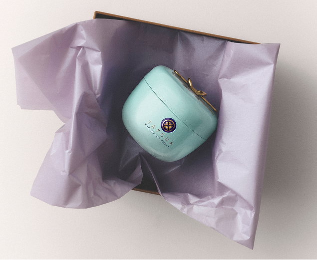 The Tatcha Water Cream inside a box with purple wrapping paper